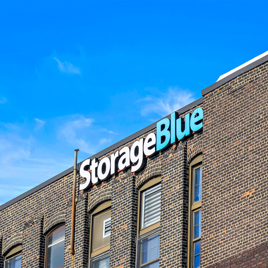 StorageBlue sign atop the brick Paterson facility against a blue sky